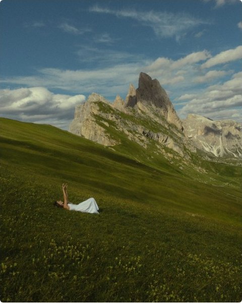 Lying in an alpine meadow beneath jagged peaks and drifting cloud